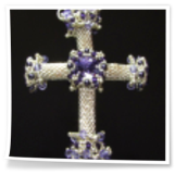 Silbernes Kreuz gefädelt aus Rocailles und lila Akzenten.